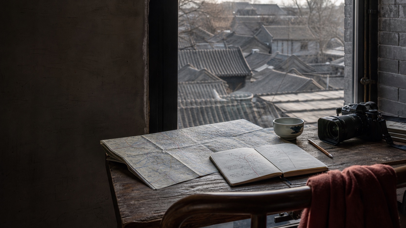 A Beijing route designer's table overlooking hutong rooftops