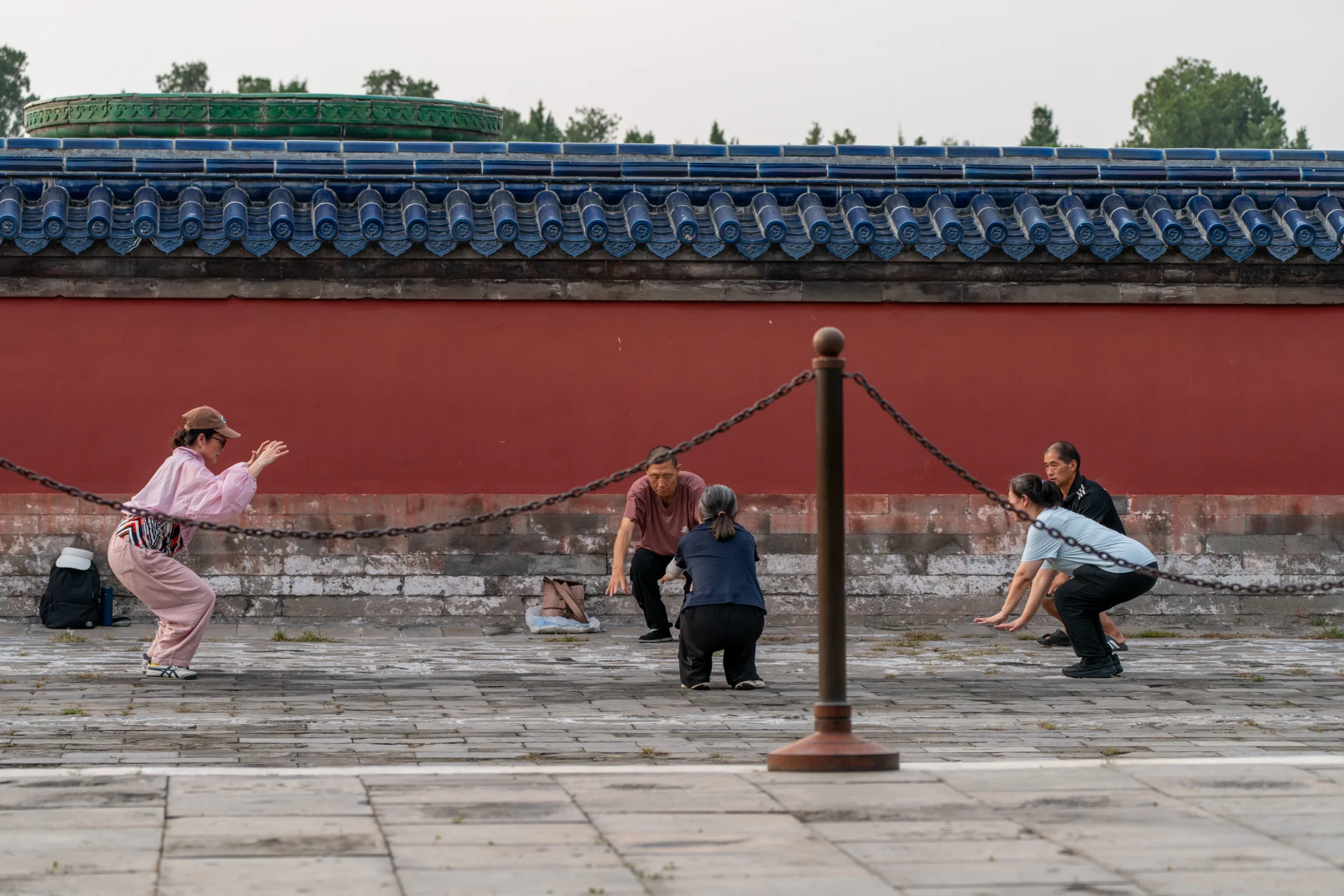 Morning exercise beside the red walls of the Temple of Heaven
