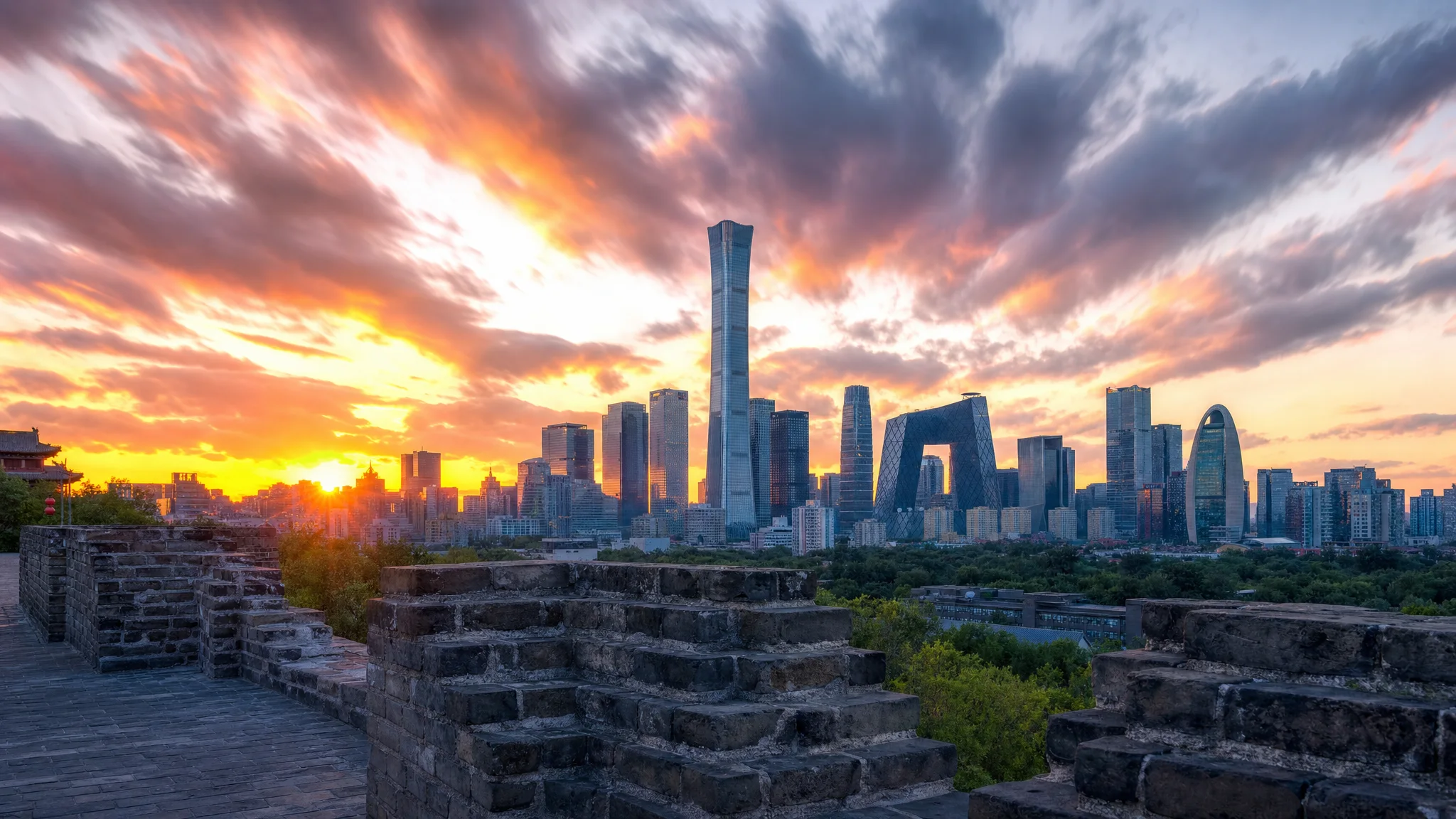 Beijing's modern skyline seen beyond an old city wall at sunset